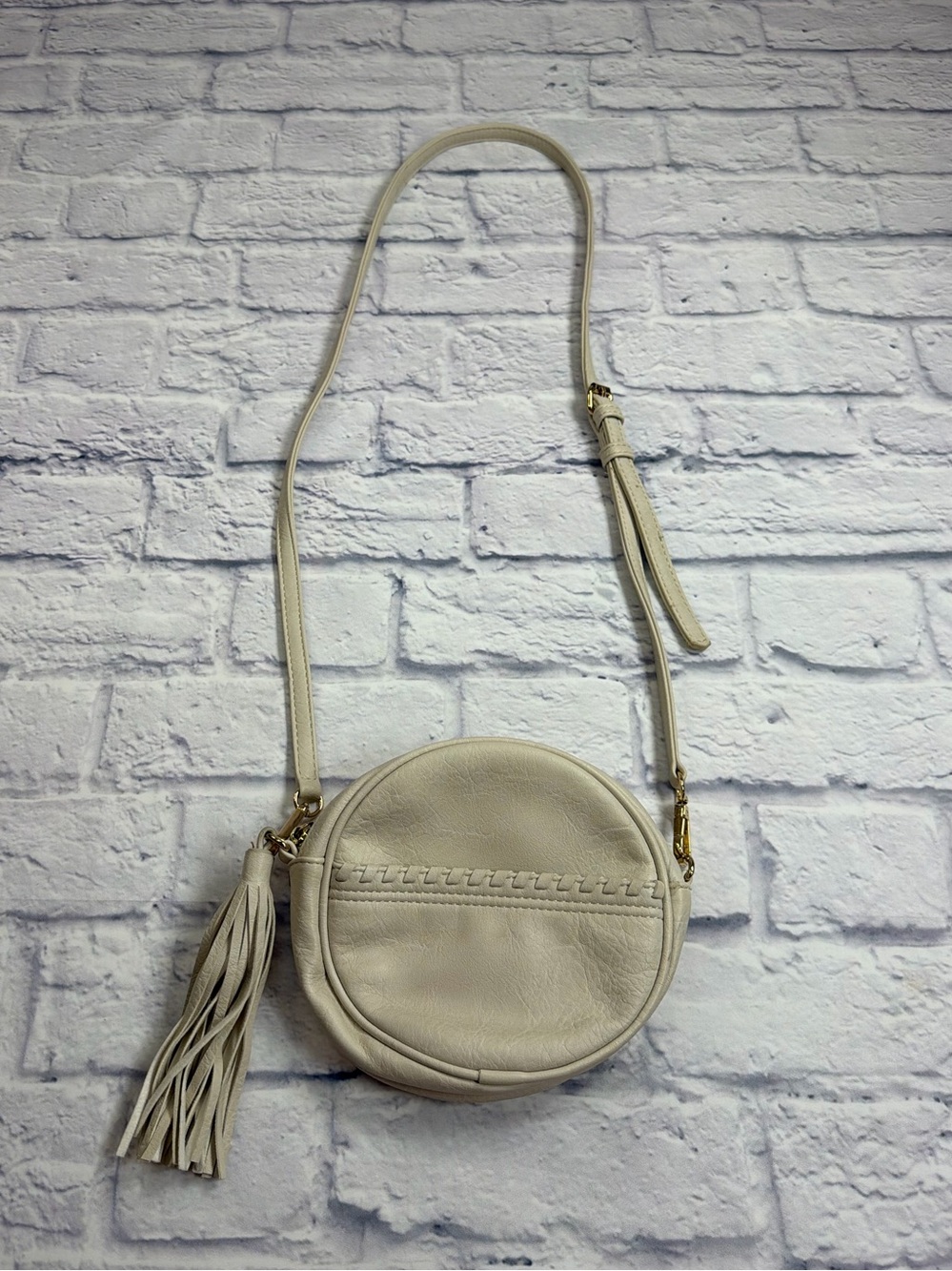 Vieta Vegan Leather Cream Round Crossbody Bag with Fringe Zipper Pull.